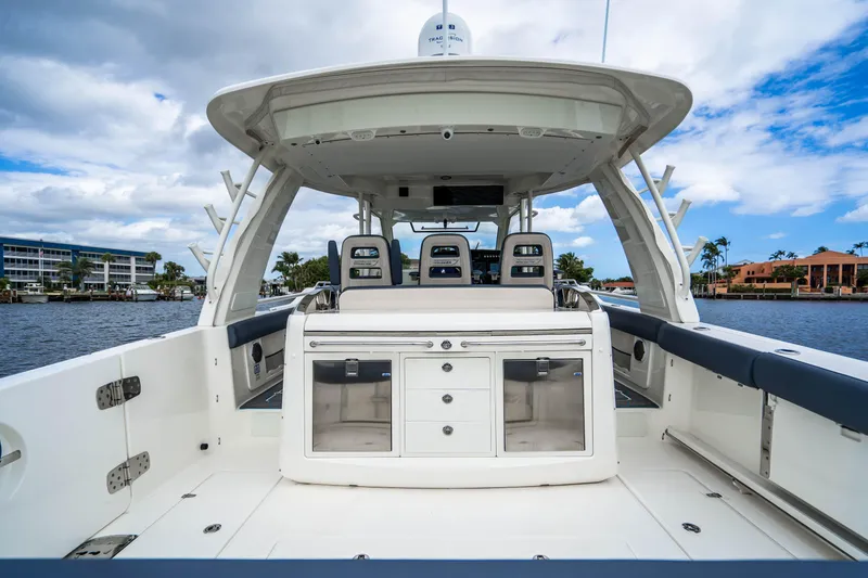 Slide: The Image of 2016 Boston Whaler 420 Outrage boat interior with seating and storage, docked by waterfront homes. - 49