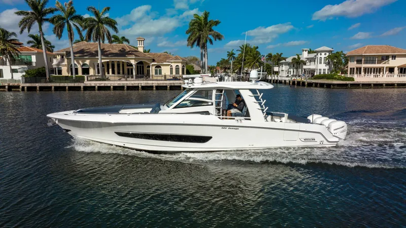 Slide: The Image of 2016 Boston Whaler 420 Outrage cruising on a scenic waterway with palm trees. - 6