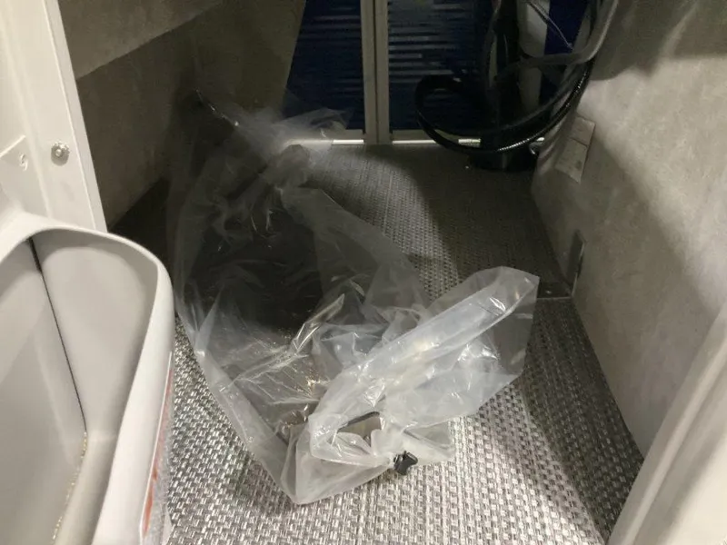 Slide: The Image of Interior storage area of a 2023 Bennington 23 LSB boat with plastic-wrapped equipment. - 13