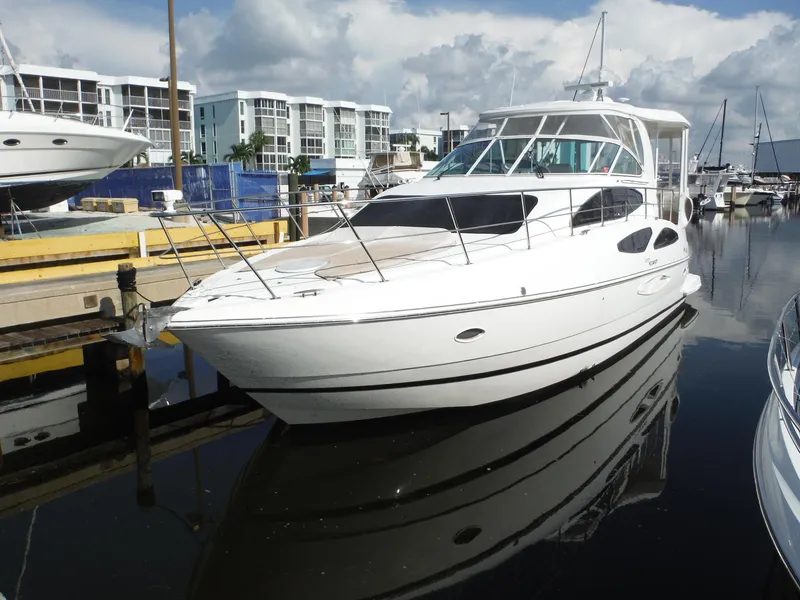 The Image of 2005 Cruisers Yachts 455 Express Motoryacht docked at marina under cloudy sky. - 0