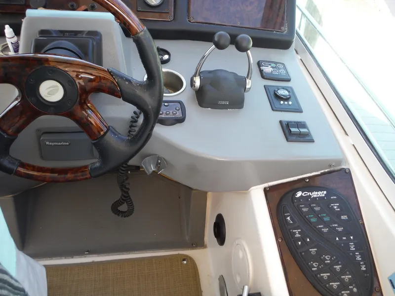 Slide: The Image of 2005 Cruisers Yachts 455 Express Motoryacht helm with steering wheel and control panel. - 12