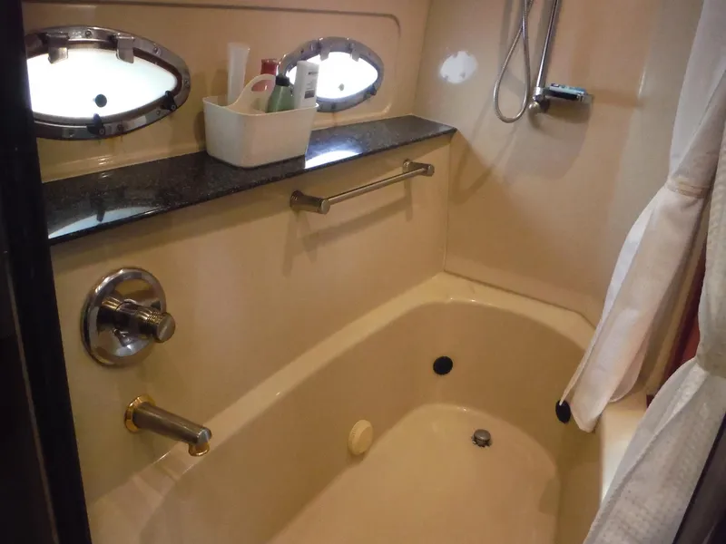Slide: The Image of 2005 Cruisers Yachts 455 Express Motoryacht bathroom with bathtub and porthole windows. - 37