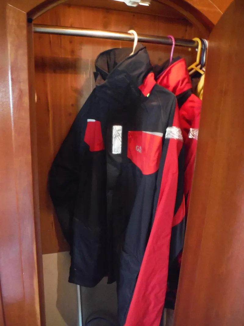 Slide: The Image of Jackets hanging in a wooden closet on a 2005 Cruisers Yachts 455 Express Motoryacht. - 44