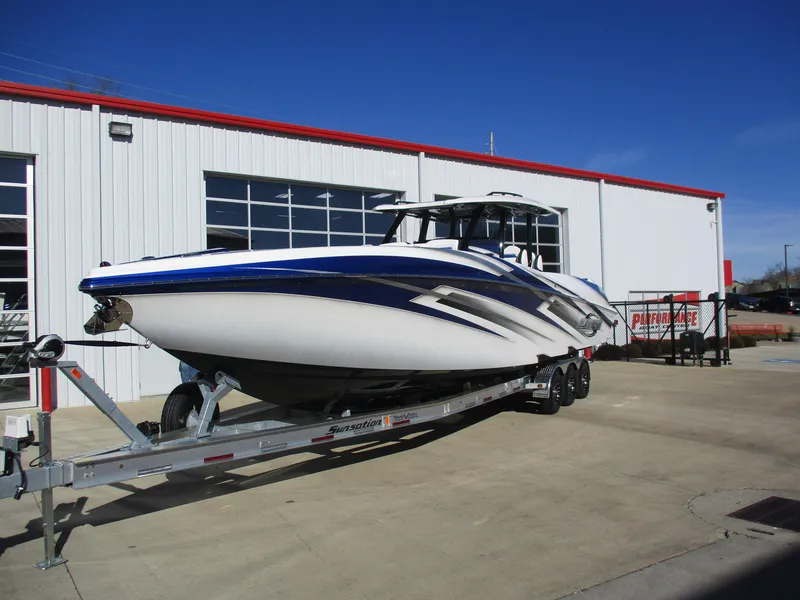 Slide: The Image of 2021 Sunsation 40CCX boat on a trailer outside a white and red building. - 3