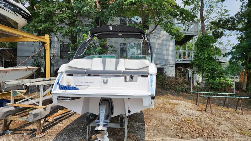 Slide: The Image of 2017 Regal 22 FasDeck boat on dry dock, surrounded by trees and buildings. - 15