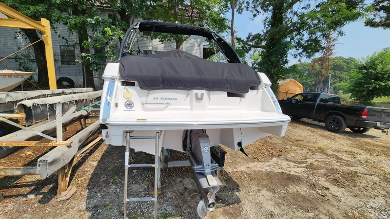 Slide: The Image of 2017 Regal 22 FasDeck boat on land, rear view with cover and ladder. - 19