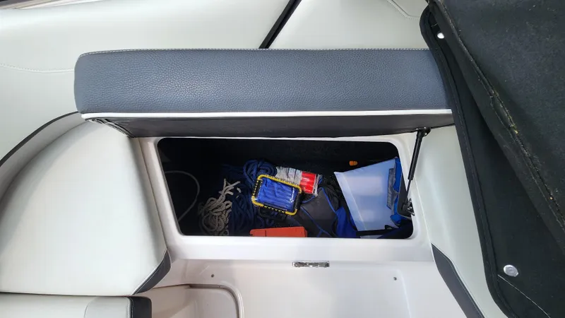 Slide: The Image of Storage compartment in 2017 Regal 22 FasDeck boat with various items inside. - 20