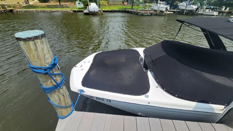 Slide: The Image of 2017 Regal 22 FasDeck boat docked with black cover on a sunny day. - 30