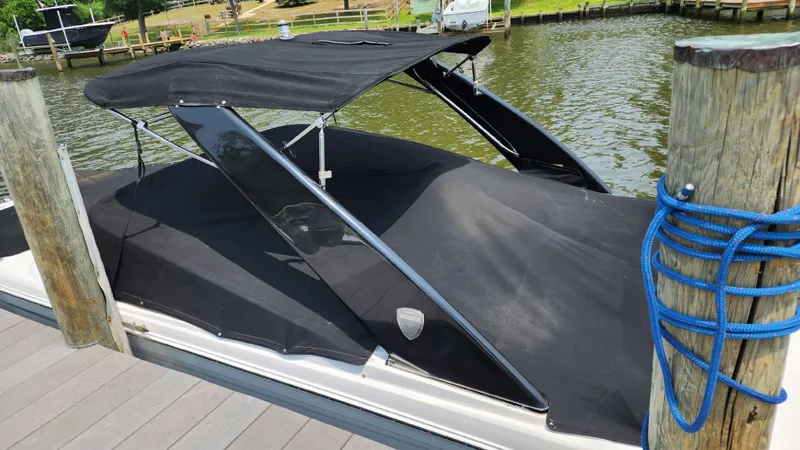 Slide: The Image of 2017 Regal 22 FasDeck boat docked with black cover and canopy. - 9