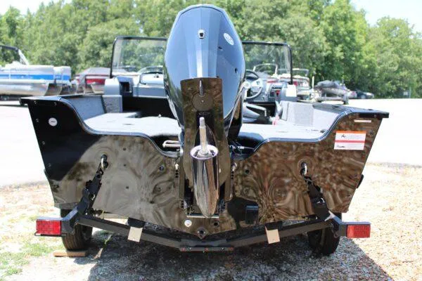 Slide: The Image of 2023 Lowe FM1675 boat rear view with outboard motor in a parking lot. - 3