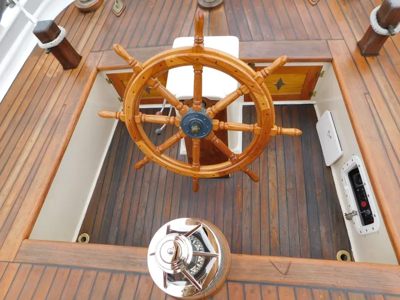 Slide: The Image of Wooden helm of 1983 Custom Murray Peterson Coaster III sailboat, featuring classic nautical design. - 10