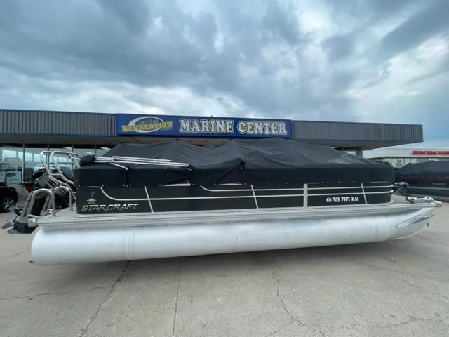 Slide: The Image of 2014 Starcraft Limited 236 pontoon boat at a marine center. - 0