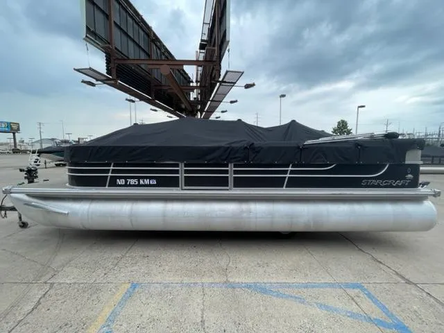 Slide: The Image of 2014 Starcraft Limited 236 pontoon boat with black cover in parking lot. - 1
