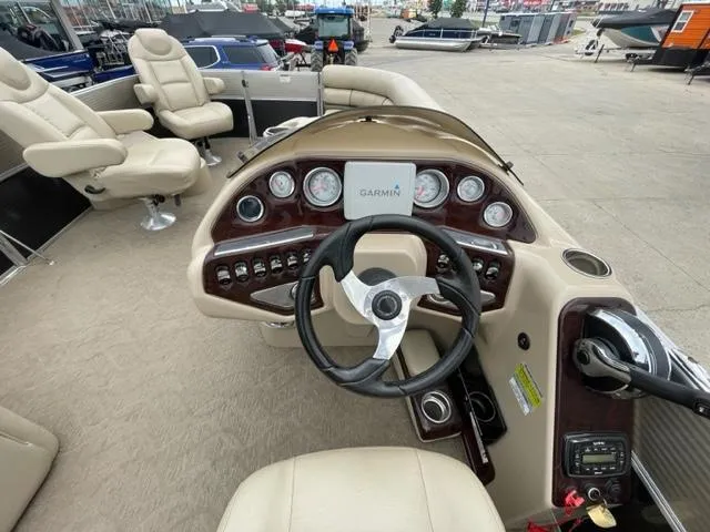 Slide: The Image of 2014 Starcraft Limited 236 boat dashboard with Garmin navigation system and beige seating. - 15