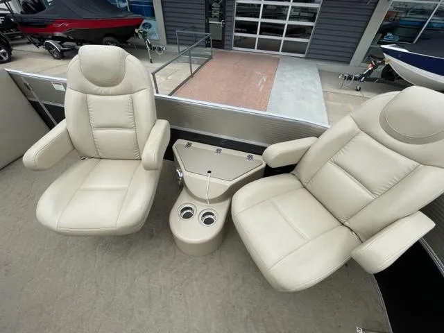 Slide: The Image of 2014 Starcraft Limited 236 boat interior with beige captain chairs and cup holders. - 6
