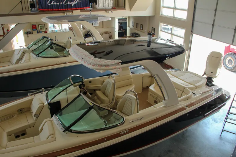 Slide: The Image of 2022 Chris-Craft Launch 25 GT boats displayed in a showroom. - 26