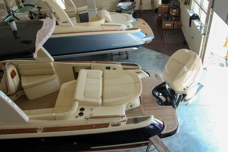Slide: The Image of 2022 Chris-Craft Launch 25 GT boat in showroom, featuring luxurious seating and modern design. - 28