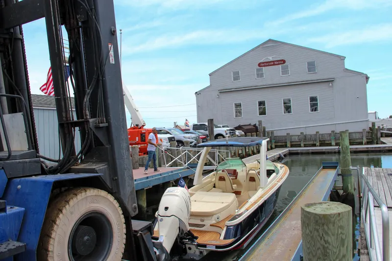 Slide: The Image of 2022 Chris-Craft Launch 25 GT boat at marina with forklift and dock. - 3