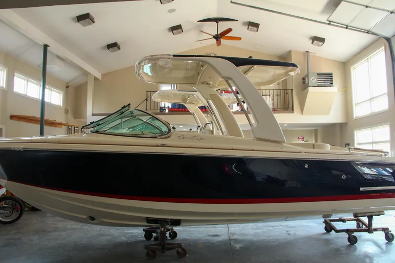 Slide: The Image of 2022 Chris-Craft Launch 25 GT boat in indoor showroom, side view. - 30