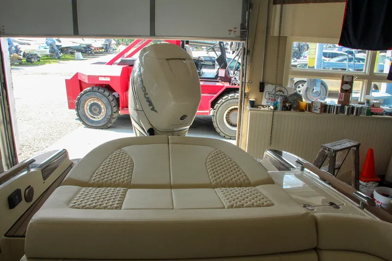 Slide: The Image of 2022 Chris-Craft Launch 25 GT in garage, featuring luxurious seating and powerful outboard motor. - 35