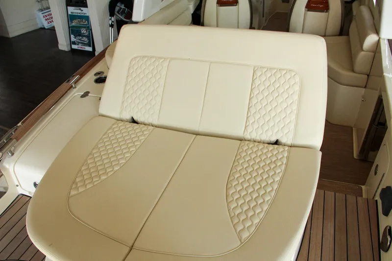 Slide: The Image of 2022 Chris-Craft Launch 25 GT interior with beige quilted seating and wooden flooring. - 36