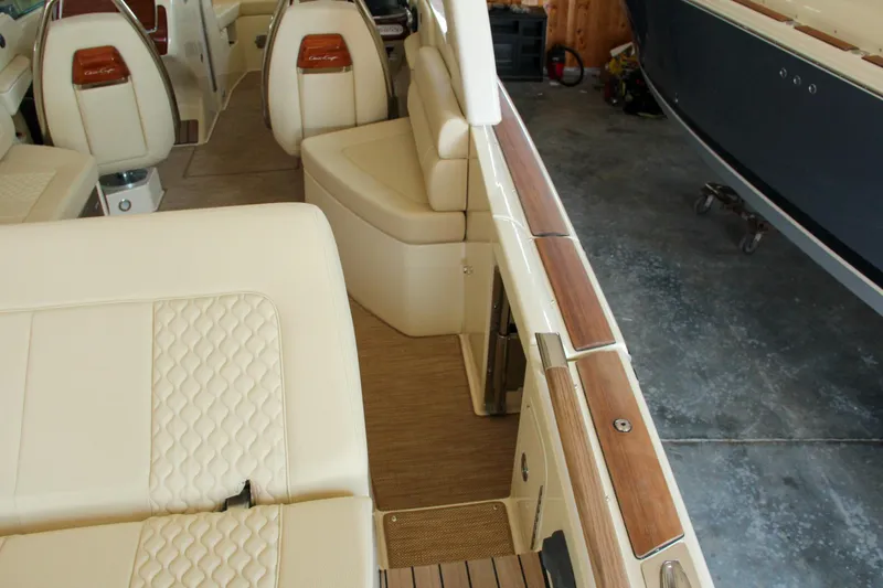 Slide: The Image of 2022 Chris-Craft Launch 25 GT interior with beige seating and wood accents in a garage setting. - 42