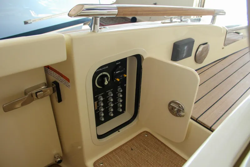 Slide: The Image of 2022 Chris-Craft Launch 25 GT control panel with open compartment and wooden deck. - 43