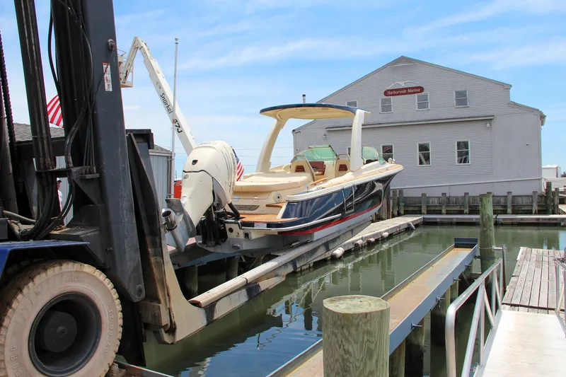Slide: The Image of 2022 Chris-Craft Launch 25 GT boat on a lift at a marina dock. - 5