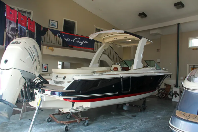 Slide: The Image of 2022 Chris-Craft Launch 25 GT boat displayed indoors with outboard motor. - 7