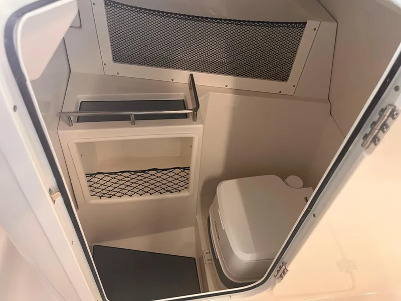 Slide: The Image of 2024 Sailfish 226 boat interior with compact toilet and storage compartments. - 13