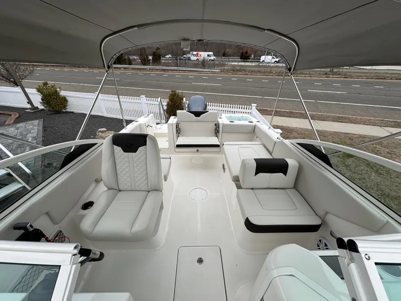 Slide: The Image of 2024 Sailfish 226 boat interior with seating and canopy, parked near a road. - 8