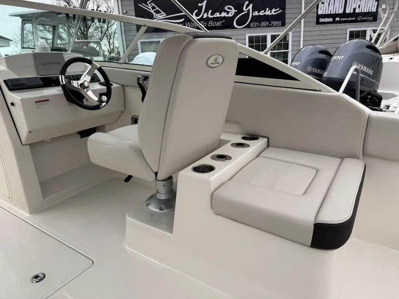 Slide: The Image of 2024 Sailfish 226 boat interior with helm, seating, and cup holders. - 9