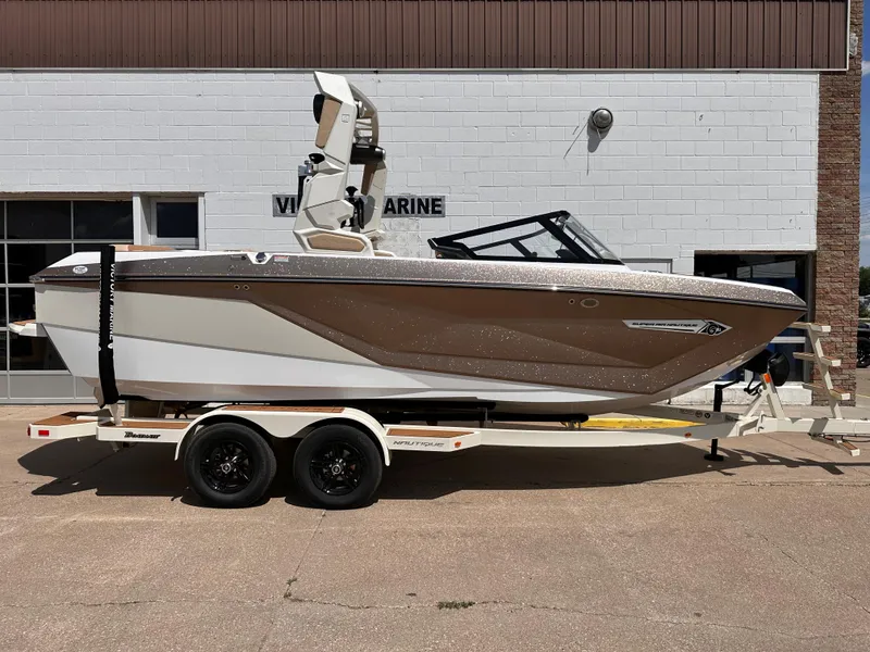 The Image of 2023 Nautique G21 boat on trailer outside marine dealership. - 1