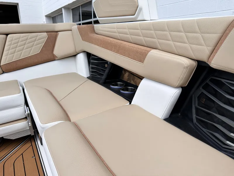 Slide: The Image of 2023 Nautique G21 boat interior with beige and brown cushioned seating. - 13
