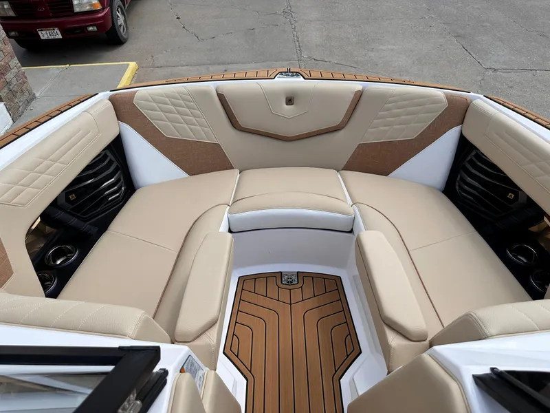 Slide: The Image of 2023 Nautique G21 boat interior with beige seating and teak flooring. - 15