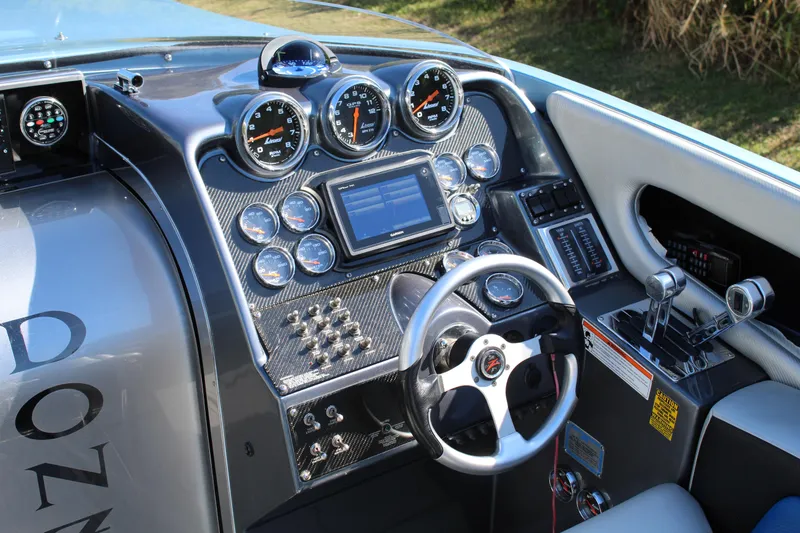 Slide: The Image of 2006 Donzi 43 ZR boat dashboard with gauges, steering wheel, and control panel. - 31