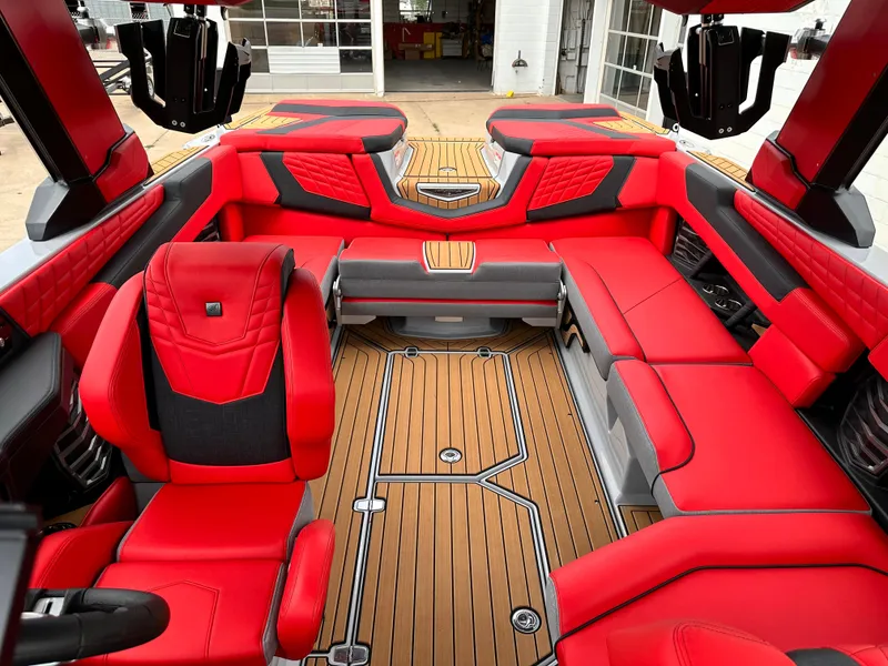 Slide: The Image of 2023 Nautique G23 boat interior with red and black seating and teak flooring. - 11