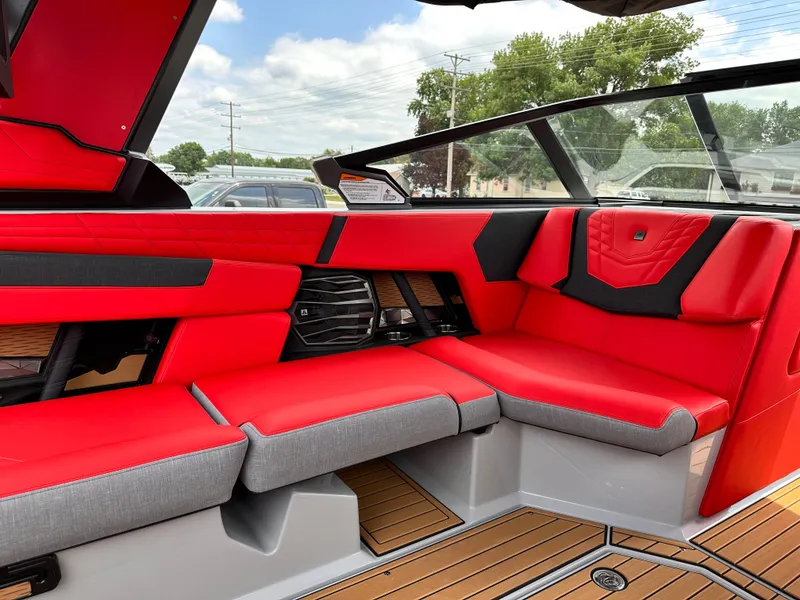 Slide: The Image of 2023 Nautique G23 boat interior with red and gray seating, modern design, and teak flooring. - 13