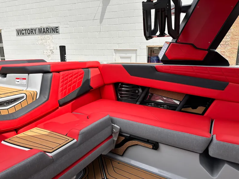 Slide: The Image of 2023 Nautique G23 boat interior with red and gray seating at Victory Marine. - 14