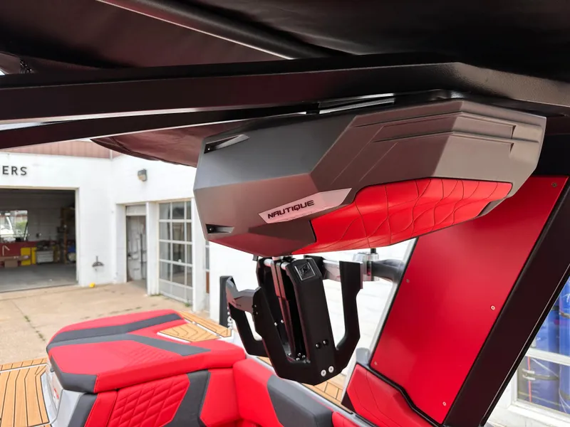 Slide: The Image of 2023 Nautique G23 boat interior with red and black upholstery and advanced sound system. - 18