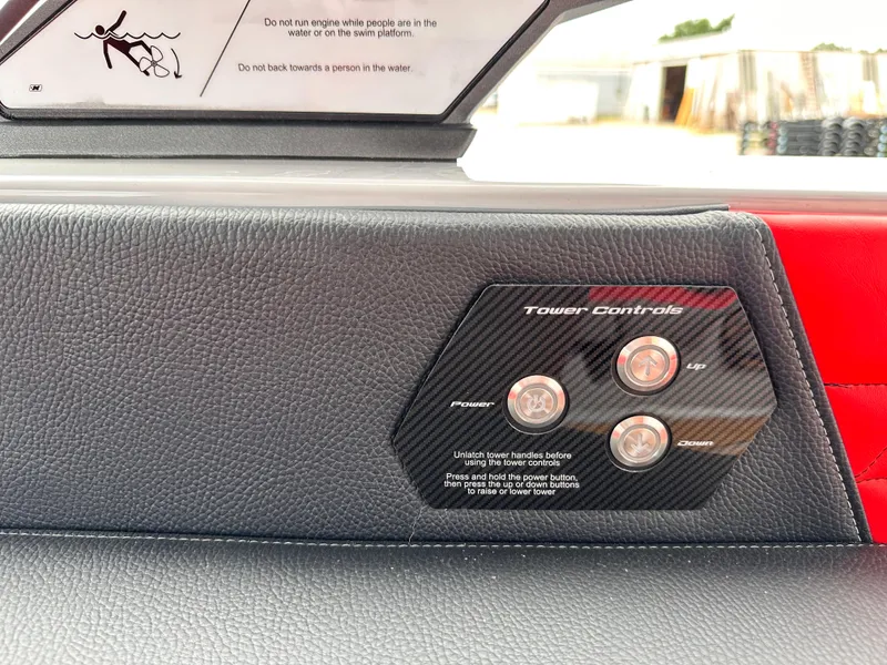 Slide: The Image of 2023 Nautique G23 boat tower controls on black leather dashboard. - 19