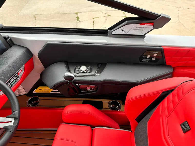 Slide: The Image of 2023 Nautique G23 boat interior with red and black seating and control panel. - 20