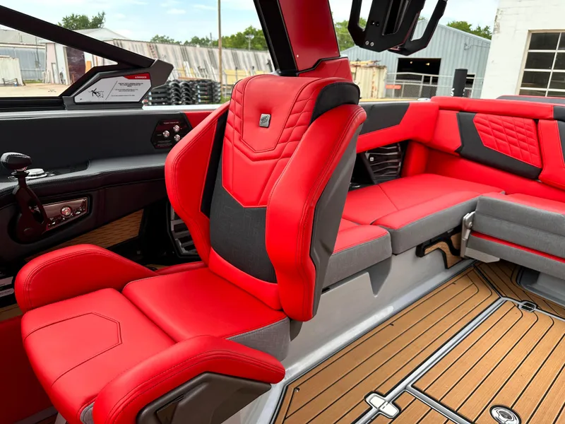Slide: The Image of 2023 Nautique G23 boat interior with red and black seats and teak flooring. - 21