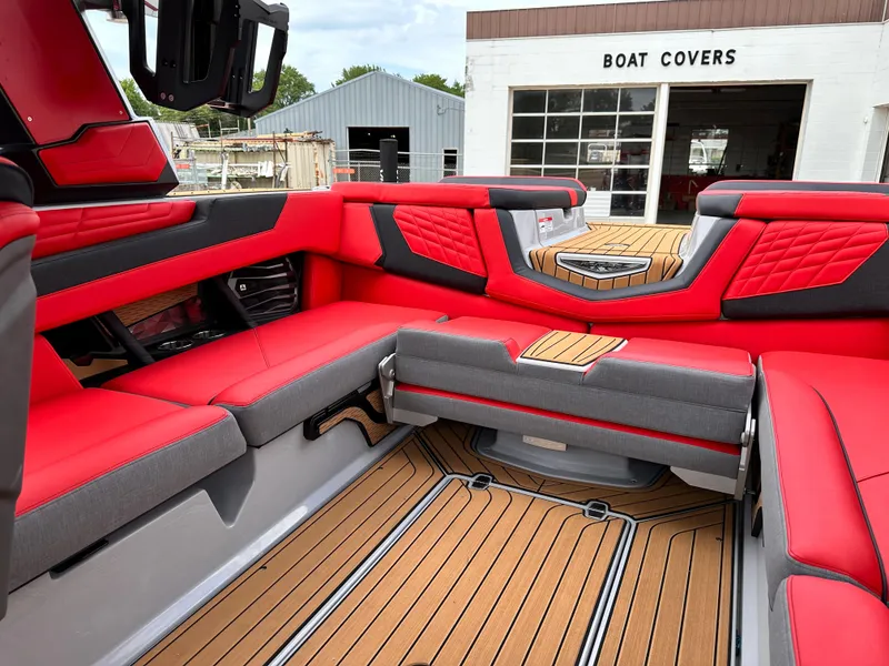 Slide: The Image of 2023 Nautique G23 boat interior with red and gray seating, teak flooring, and modern design. - 22