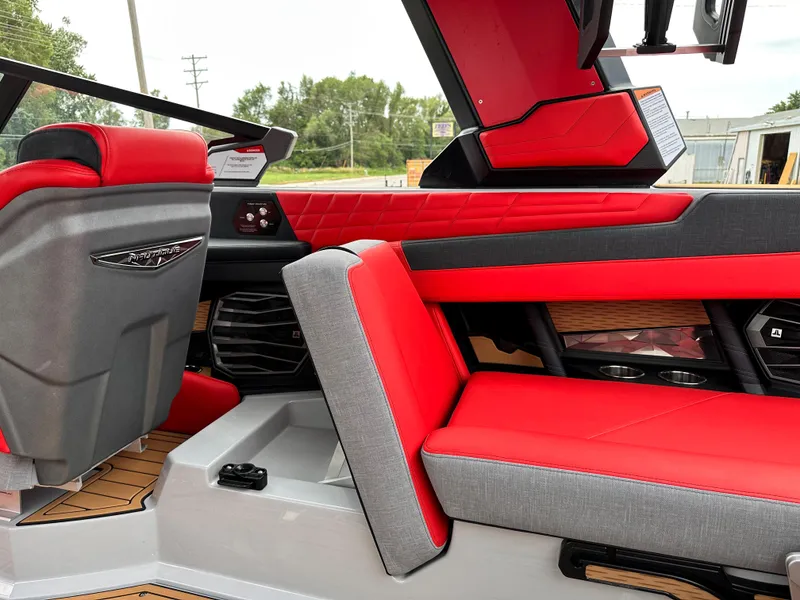 Slide: The Image of 2023 Nautique G23 boat interior with red and gray seating, modern design. - 23