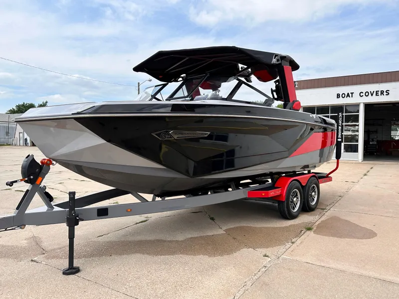 Slide: The Image of 2023 Nautique G23 boat on trailer outside a boat cover shop. - 3