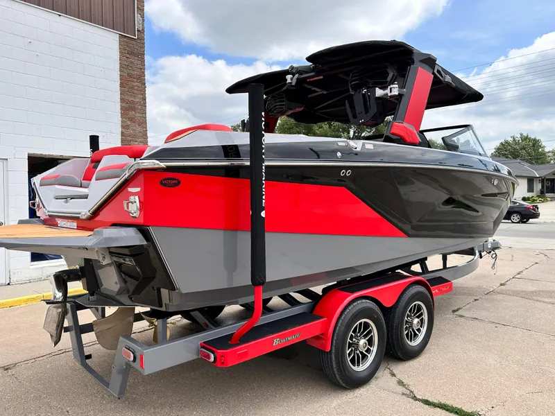 Slide: The Image of 2023 Nautique G23 boat on a red trailer, parked outdoors. - 6