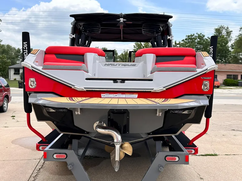 Slide: The Image of 2023 Nautique G23 boat rear view with red and gray seating. - 8
