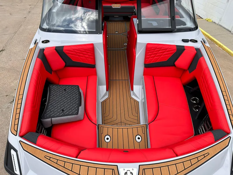 Slide: The Image of 2023 Nautique G23 boat interior with red and black seating, teak flooring. - 9
