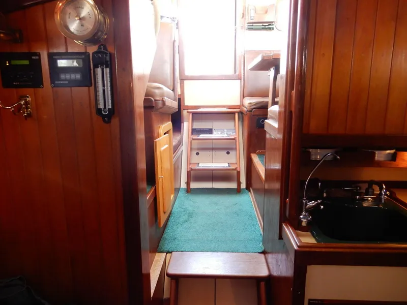 Slide: The Image of 1977 Ted Brewer Jason Pilothouse Offshore interior with wood paneling and green carpet. - 2